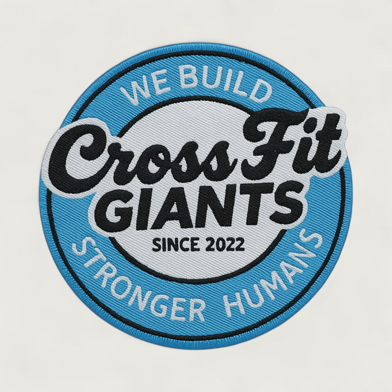Round woven patch with blue and white background featuring the text 'CrossFit Giants – We Build Stronger Humans – Since 2022' in bold lettering, designed for fitness apparel or gym branding
