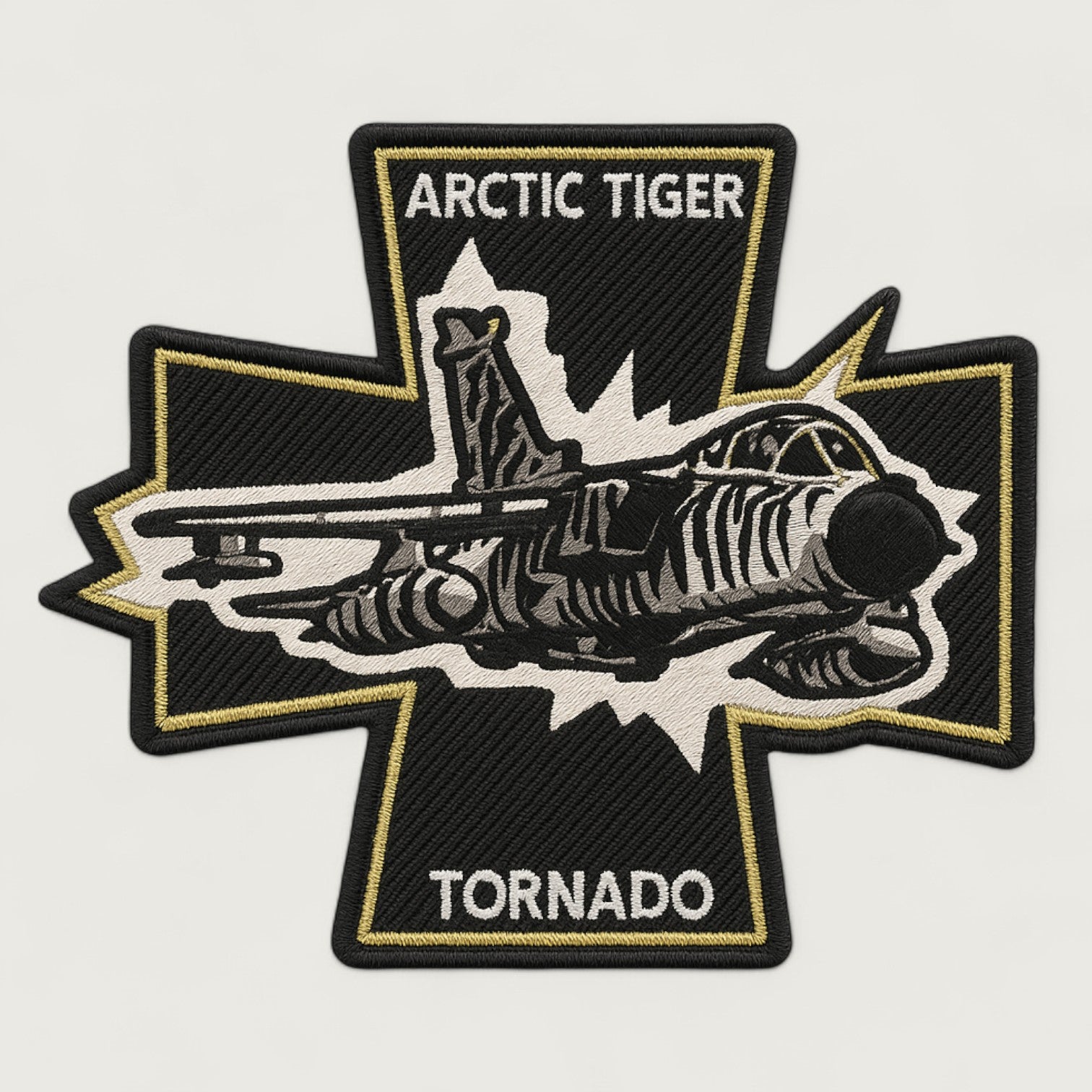 Embroidered patch shaped like a black cross with gold border, featuring a fighter jet in tiger-stripe camouflage and text 'Arctic Tiger Tornado' – military aviation patch design.