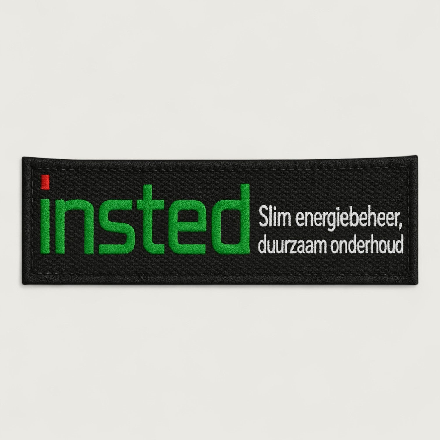 Custom rectangular embroidered patch featuring the green and white 'insted' logo with the Dutch tagline 'Slim energiebeheer, duurzaam onderhoud' on a black background