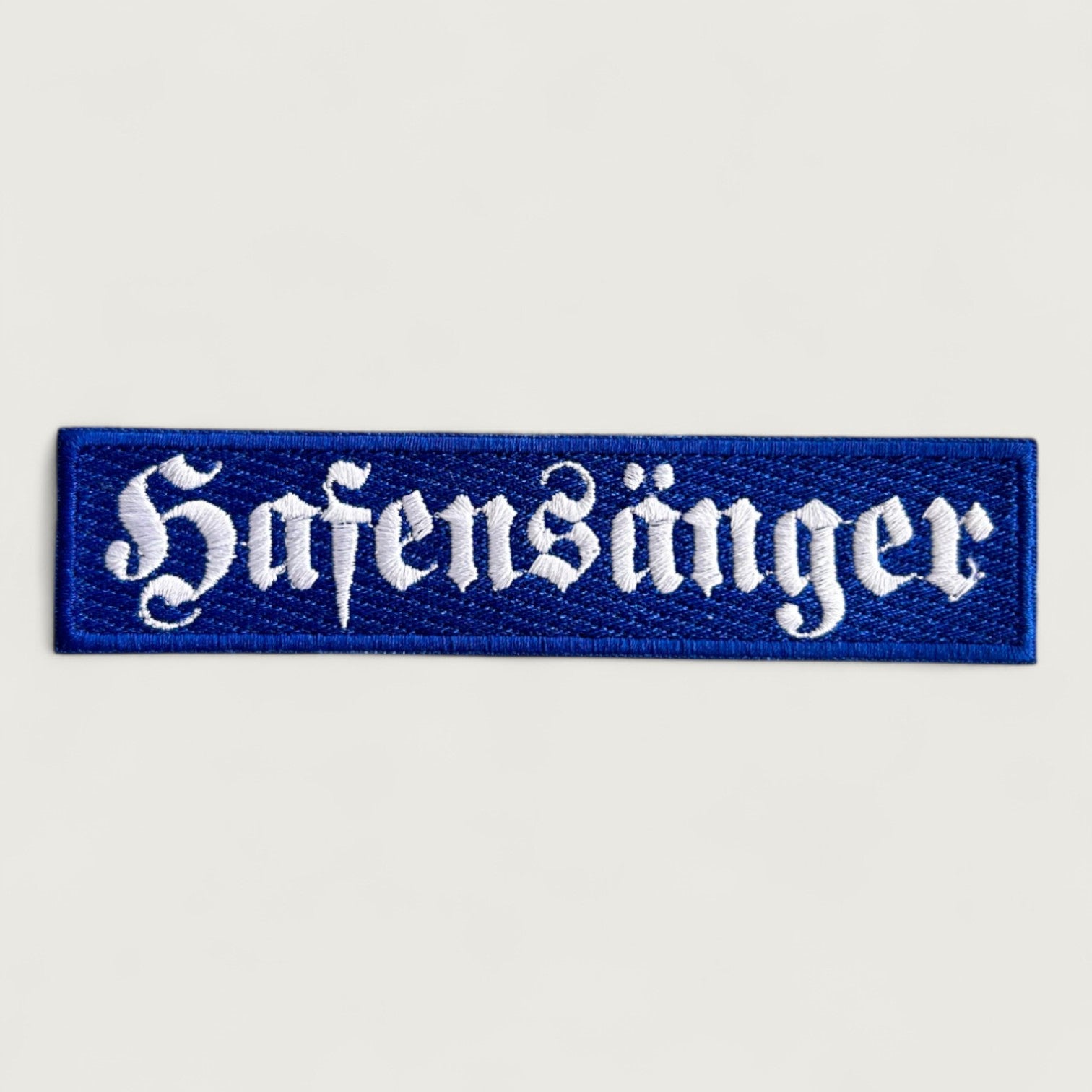 Rectangular blue embroidered patch with white gothic-style text 'Hafensänger' – custom German text patch for maritime or folk music fans