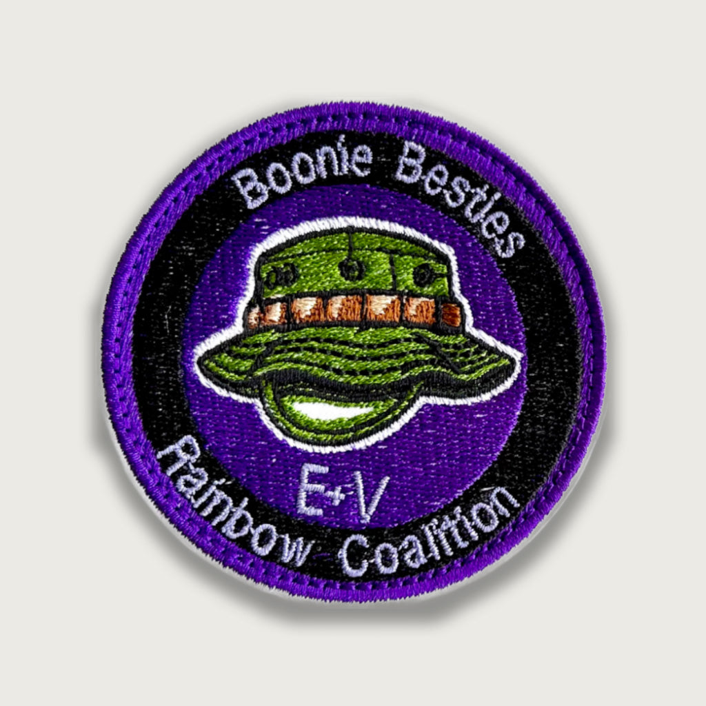 Embroidered patch with a green boonie hat on a purple background, surrounded by the text "Boonie Besties Rainbow Coalition E+V". Military-style design symbolizing friendship and unity