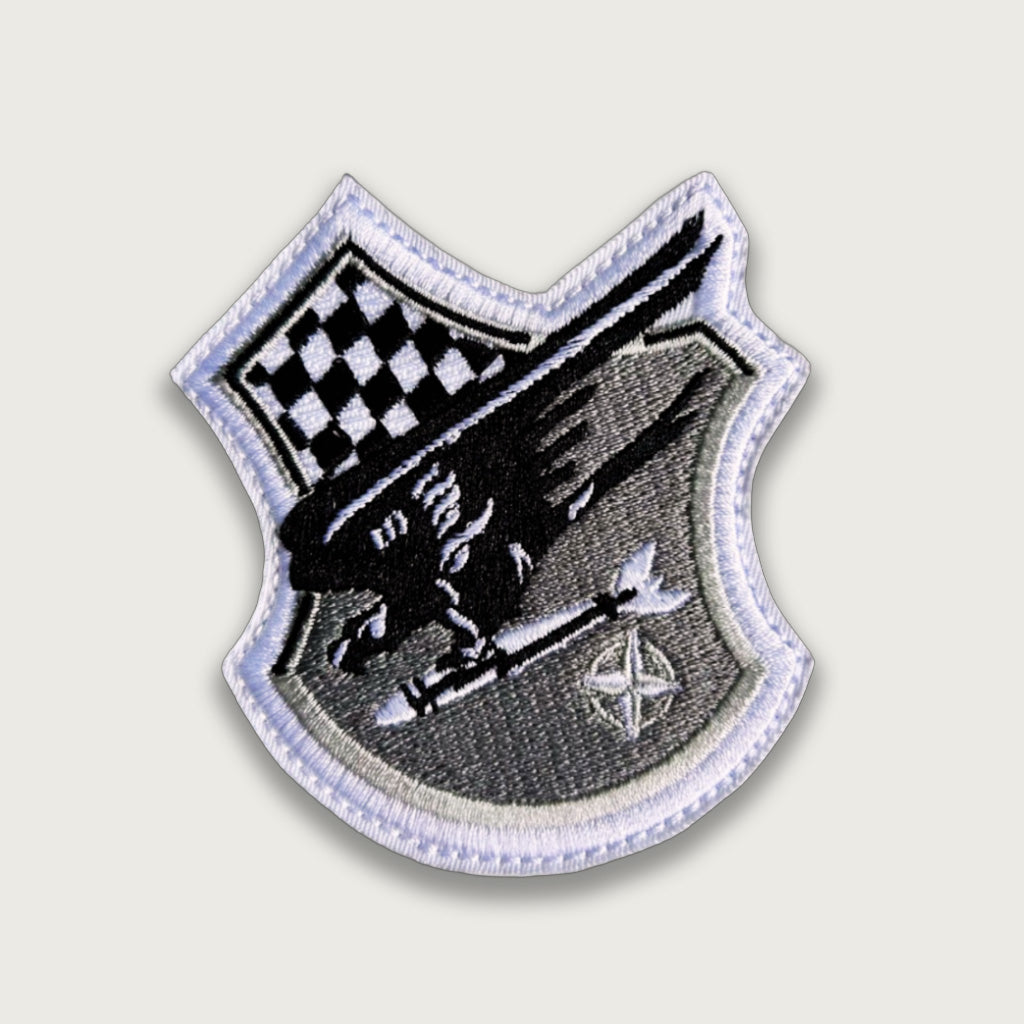 Embroidered NATO patch – Shield shape with black winged figure, missile, checkered flag, and NATO star emblem