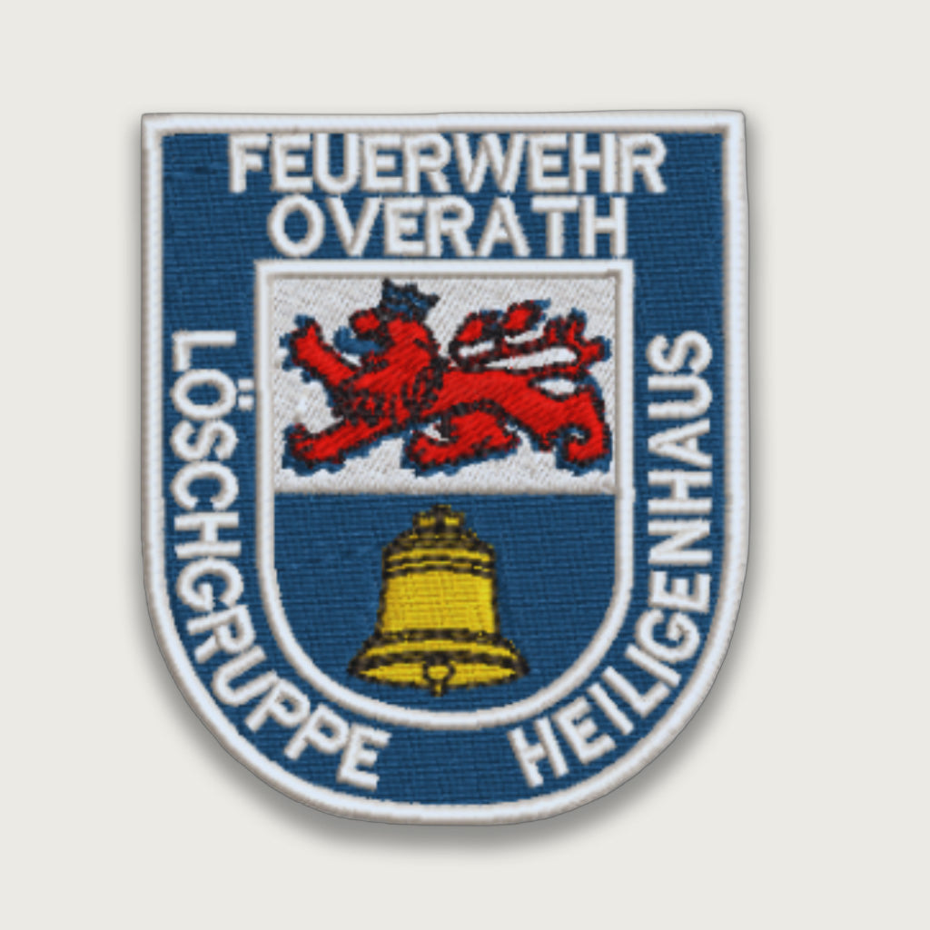 Embroidered German firefighter patch from Feuerwehr Overath Löschgruppe Heiligenhaus, featuring a red lion and yellow bell on a blue and white shield
