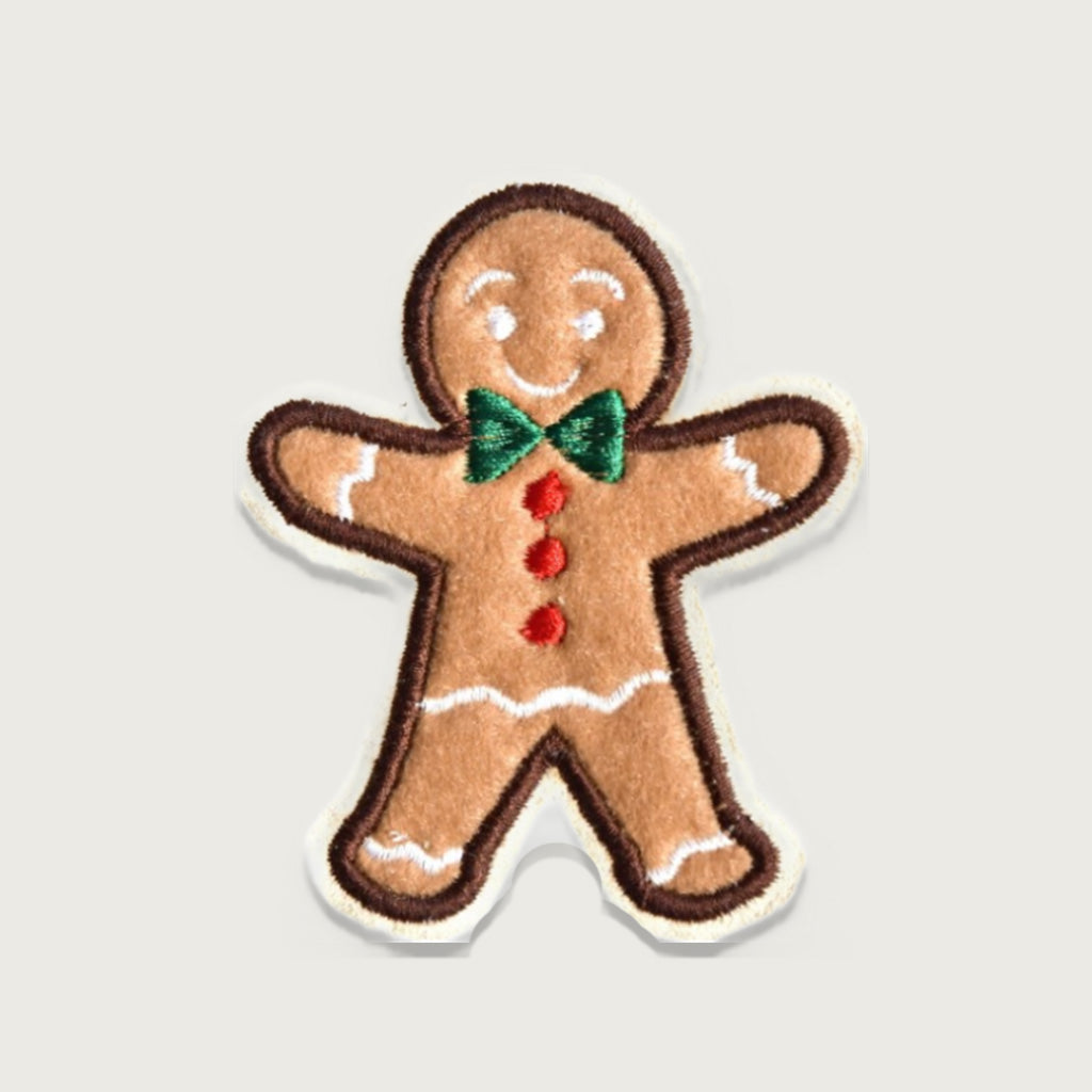Adorable embroidered gingerbread man patch with green bow tie and red buttons, perfect for Christmas clothing, festive crafts, or holiday accessories