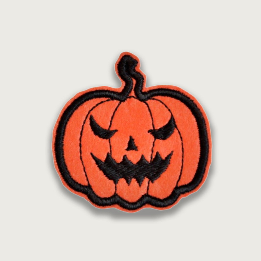 Orange embroidered Halloween pumpkin patch with a spooky black jack-o'-lantern face, ideal for decorating costumes, jackets, or bags