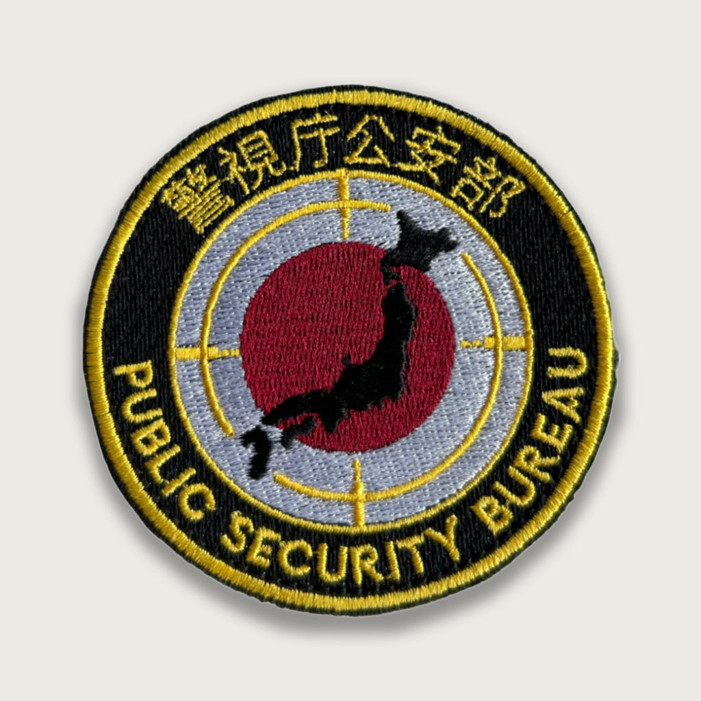 Embroidered Japan Public Security Bureau patch featuring a red sun, black map of Japan, and yellow Japanese and English text on a black background